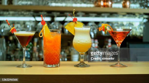 verschiedene cocktails im glas an der bartheke - cocktail counter stock-fotos und bilder