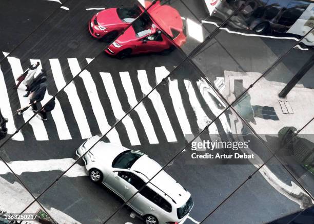 urban building reflection in city intersection with cars and pedestrians. - building reflection stock pictures, royalty-free photos & images