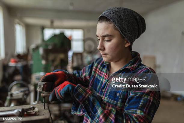 adolescent caucasien, répare son vélo au garage - lime photos et images de collection