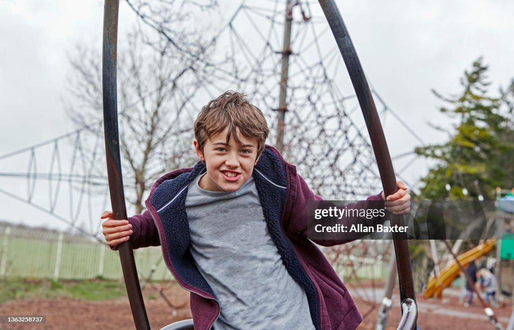Boy (8-9 years old) playing in outdoor park