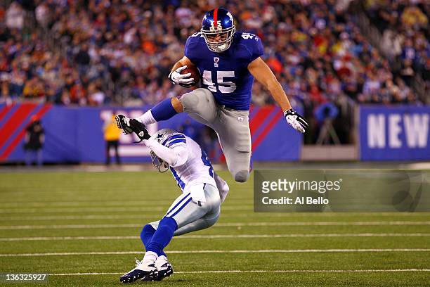 Henry Hynoski of the New York Giants leaps over Terence Newman of the Dallas Cowboys at MetLife Stadium on January 1, 2012 in East Rutherford, New...
