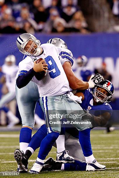 Osi Umenyiora of the New York Giants attempts to tackle Tony Romo of the Dallas Cowboys at MetLife Stadium on January 1, 2012 in East Rutherford, New...