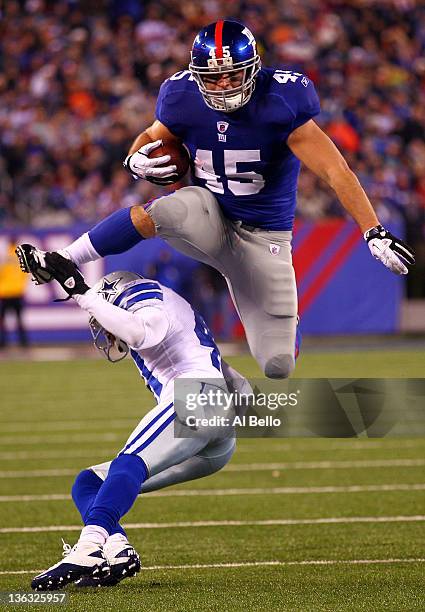 Henry Hynoski of the New York Giants leaps over Terence Newman of the Dallas Cowboys at MetLife Stadium on January 1, 2012 in East Rutherford, New...