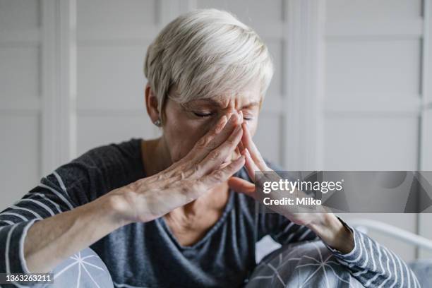 senior woman suffers from depression and headaches - only senior women stock pictures, royalty-free photos & images