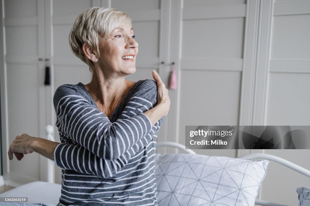 Senior woman is waking up in the morning