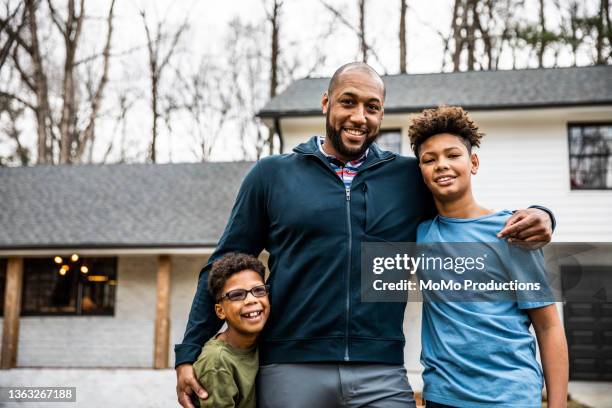 portrait of father and sons in front of residential home - native african ethnicity stock-fotos und bilder