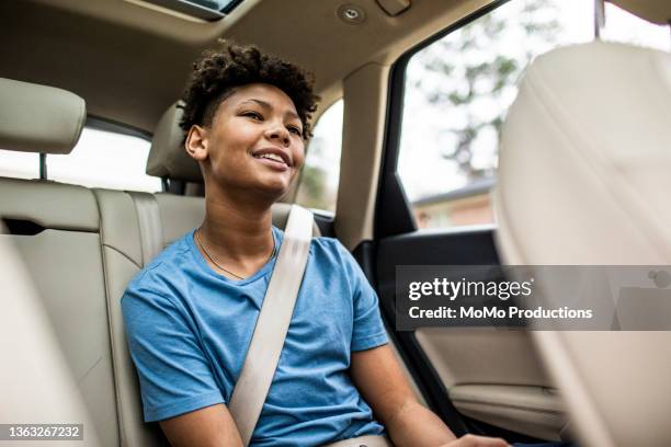 teenage boy in the back of car - cinturón de seguridad fotografías e imágenes de stock