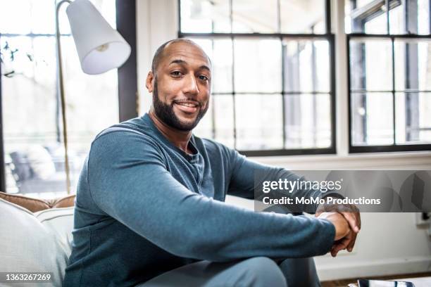 portrait of father at home in residential living room - business aspiration looking stock-fotos und bilder