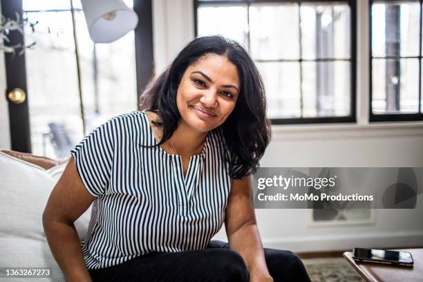 portrait of mother at home in residential living room - woman 40 stock-fotos und bilder