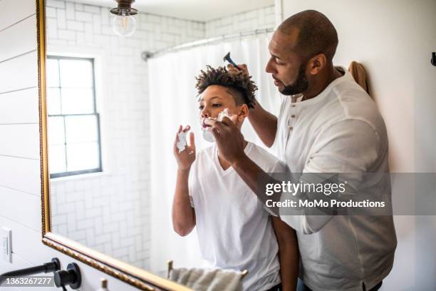 father teaching teenage son to shave in bathroom - man shaving foam stock pictures, royalty-free photos & images