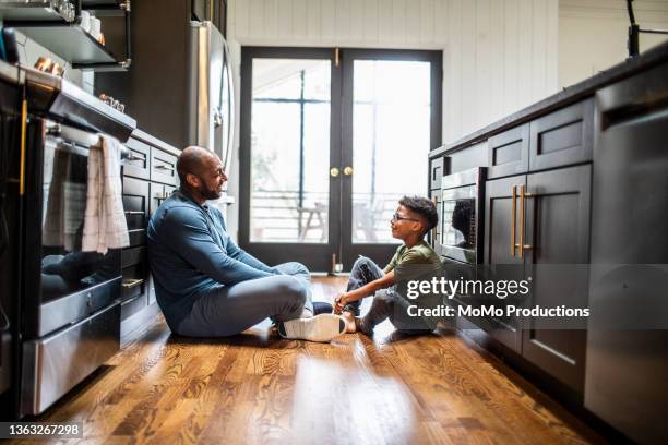 father talking with tween son in residential kitchen - father and son discussion ストックフォトと画像