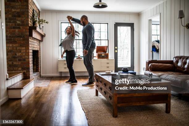 married couple dancing in residential living room - couple dancing at home stockfoto's en -beelden