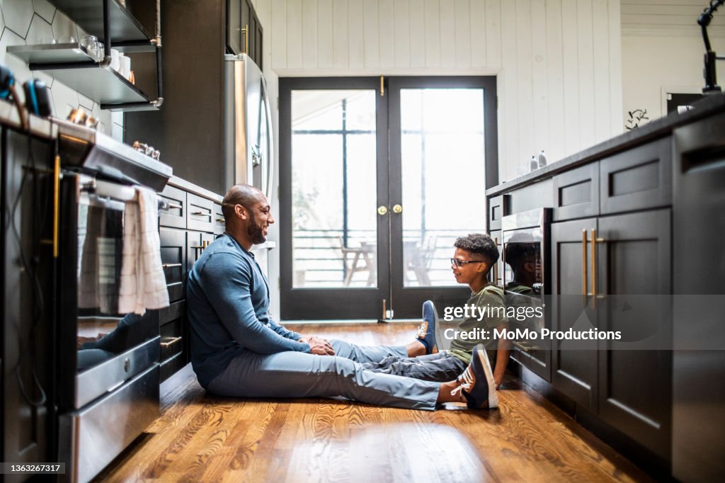 Father talking with tween son in residential kitchen