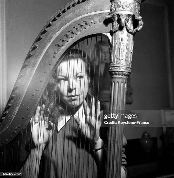 Portrait de l'écrivaine Cécile Aubry avec une harpe, le 20 mars 1952.