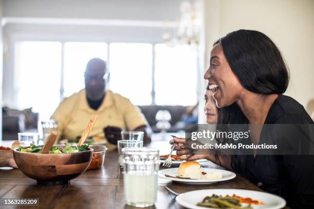 multi-generational family talking at dining room table - dish networks stock pictures, royalty-free photos & images