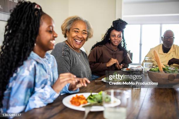 multi-generational family talking at dining room table - old man woman christmas stockfoto's en -beelden