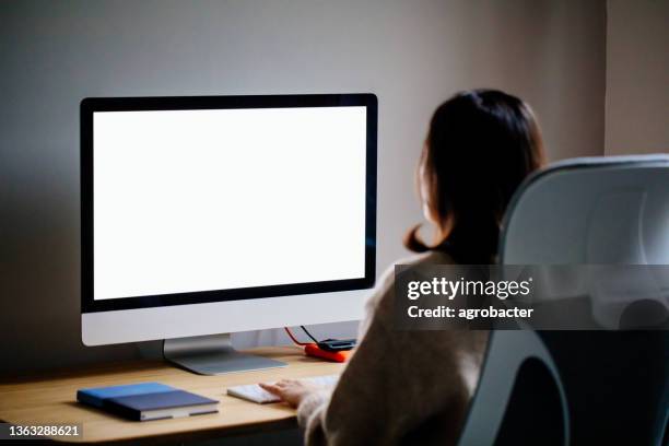 woman working at home with blank screen pc - terugkijken stockfoto's en -beelden