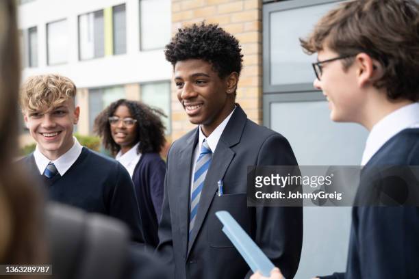 cheerful students in mid-teens interacting between classes - secondary school london stock pictures, royalty-free photos & images