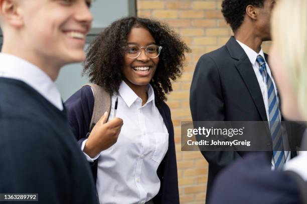 männliche und weibliche teenager interagieren zwischen den klassen - school uniform stock-fotos und bilder