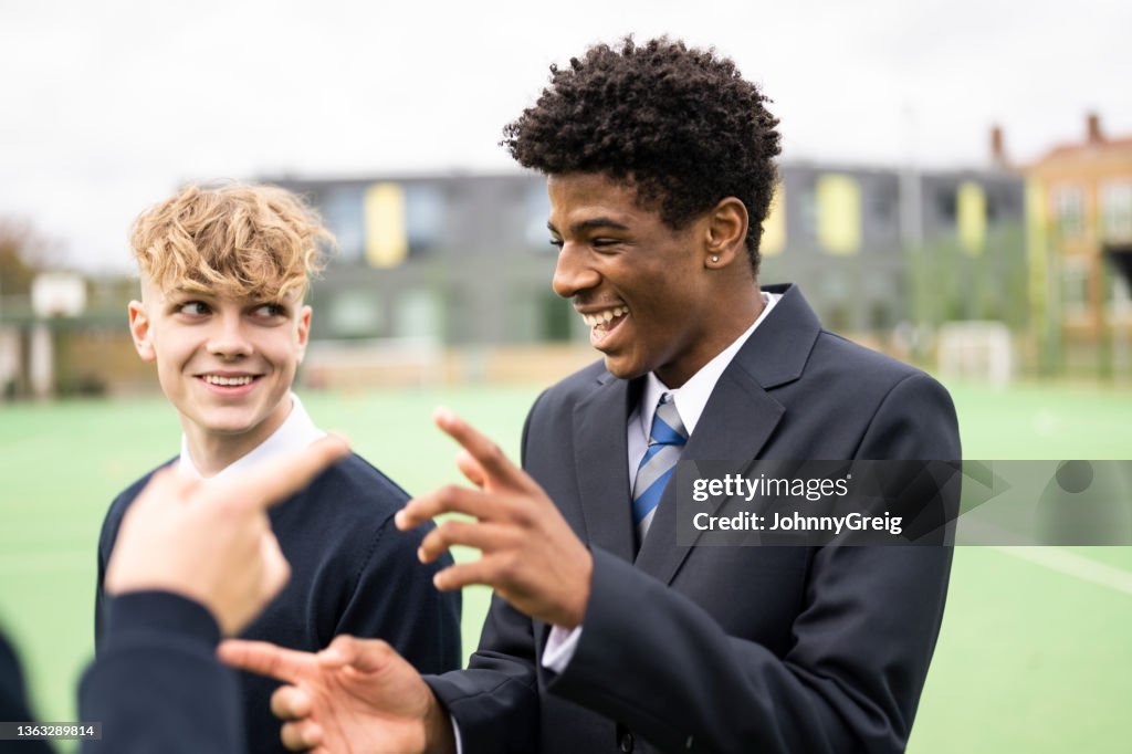 Candid outdoor portrait of playful schoolboys on campus