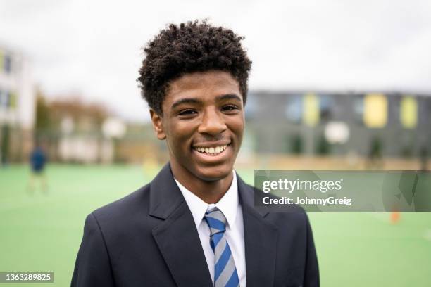 campus portrait of cheerful black schoolboy in uniform - schooluniform stockfoto's en -beelden