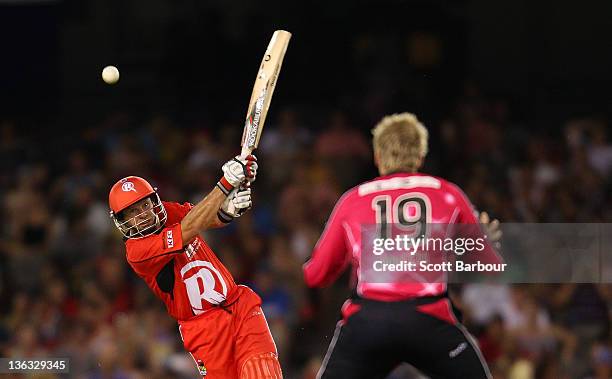 Brad Hodge of the Renegades bats as Steve Smith of the Sixers looks on in the field during the T20 Big Bash League match between the Melbourne...