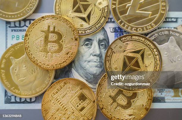 nahaufnahme von bitcoin und altmünzen kryptowährung über einem hundert-dollar-schein stehen. hohe winkelansicht, keine menschen - cryptocurrencies stock-fotos und bilder
