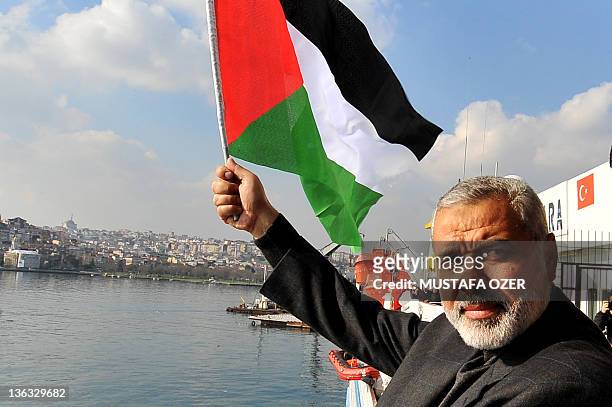 Gaza's Hamas prime minister Ismail Haniy waves a Palestinian flag during his visit on board the Turkish passenger ship Mavi Marmara in Istanbul, on...