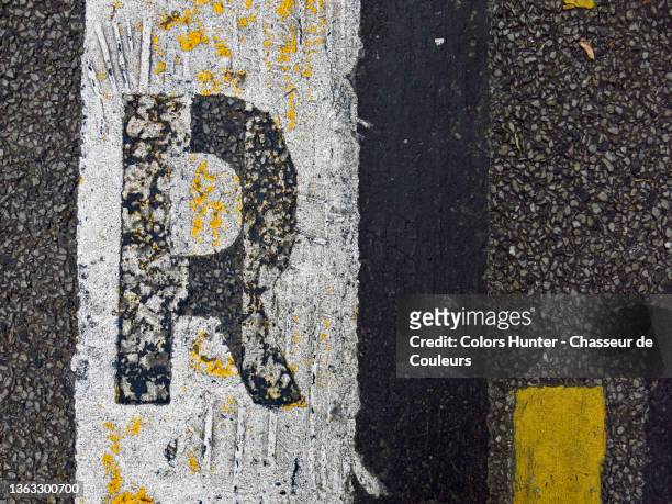 capital letter r of a painted and weathered road markings in paris - letter r stock-fotos und bilder