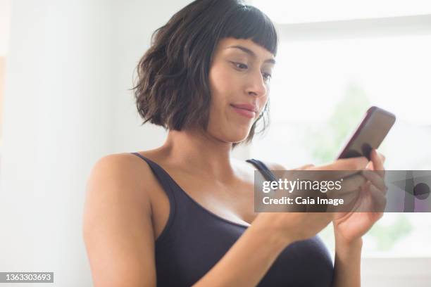 woman in bra using smart phone - short hair women stock pictures, royalty-free photos & images