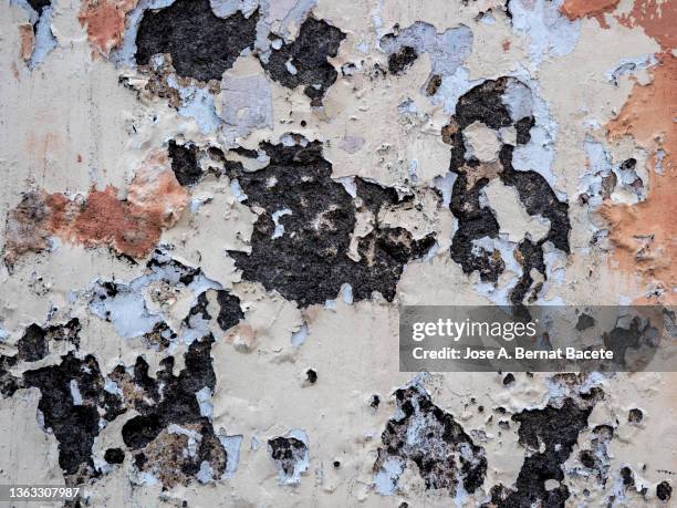wall with peeling pink and white paint with cracks and dampness. high resolution photography. - luchtvochtigheid stockfoto's en -beelden