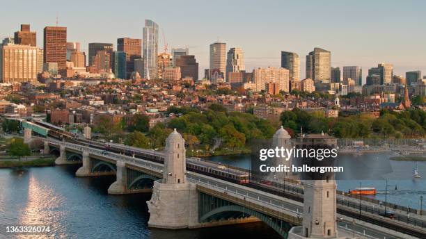 red line trains crossing on longfellow bridge at sunset - aerial - beacon hill stock pictures, royalty-free photos & images