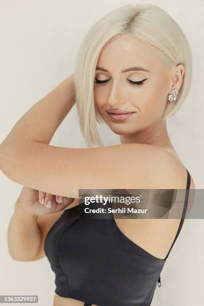 beautiful blond woman portrait with closed eyes and stylish short hairstyle in move - stock photo - platinum blonde hair stock pictures, royalty-free photos & images