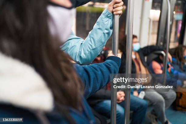 passengers in masks riding in wagon of subway - barandilla fotografías e imágenes de stock