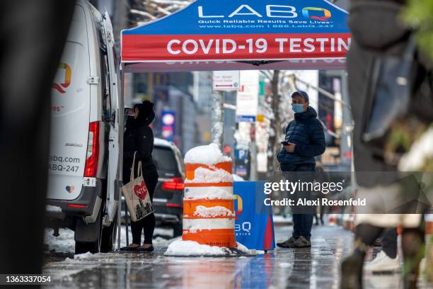 People wait in a COVID-19 testing line in Midtown during the first snow storm of the season on January 7, 2022 in New York City. According to the...