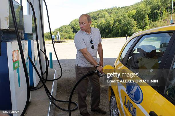 Russia's Prime Minister Vladimir Putin refuels a Russian-made Lada Kalina car as he stops at the petrol station in the Khabarovsk region on August...