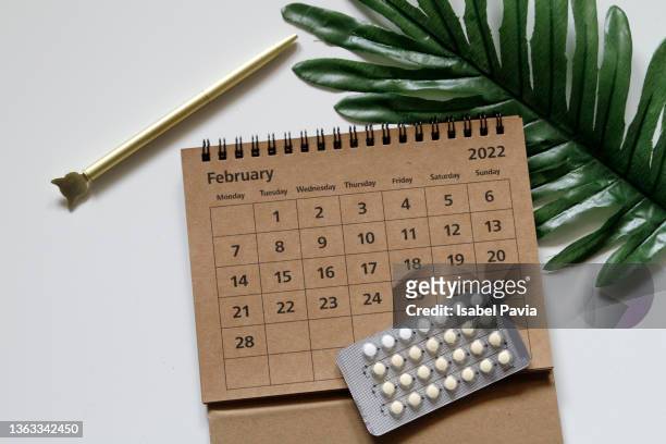 2022 february calendar and contraceptive blister pack on desk - contraceptive patch foto e immagini stock