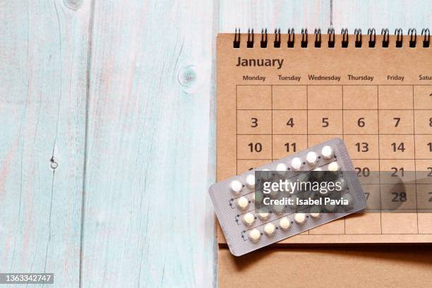 2022 january calendar and contraceptive blister pack on desk - contraceptive patch fotografías e imágenes de stock