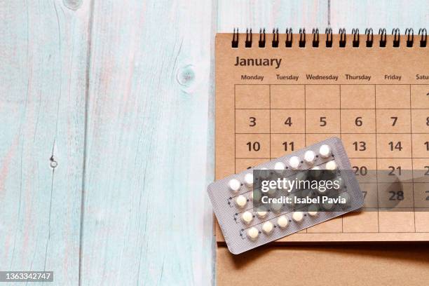 2022 january calendar and contraceptive blister pack on desk - contraceptive patch stock pictures, royalty-free photos & images