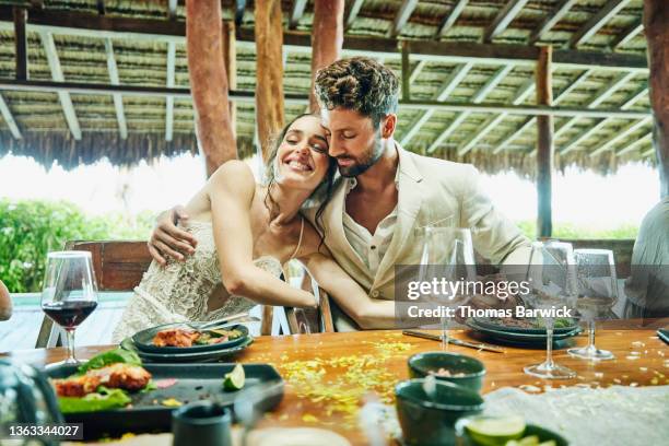 medium wide shot of bride and groom embracing during wedding reception dinner at luxury tropical resort - dinner reception for the wedding of lee radziwill and herb ross stockfoto's en -beelden