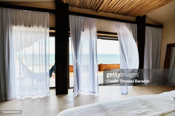wide shot of curtains blowing in wind in luxury suite at tropical resort - curtain blowing stock pictures, royalty-free photos & images