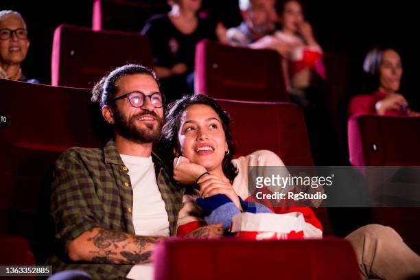retrato de una joven pareja disfrutando mientras ve una comedia romántica en el cine - lovers 2020 film fotografías e imágenes de stock