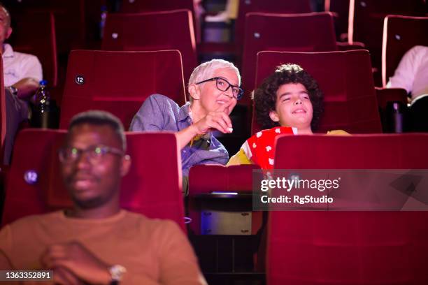 boy and his grandma watching a comedy film at the cinema and having fun - good boy premiere stock pictures, royalty-free photos & images