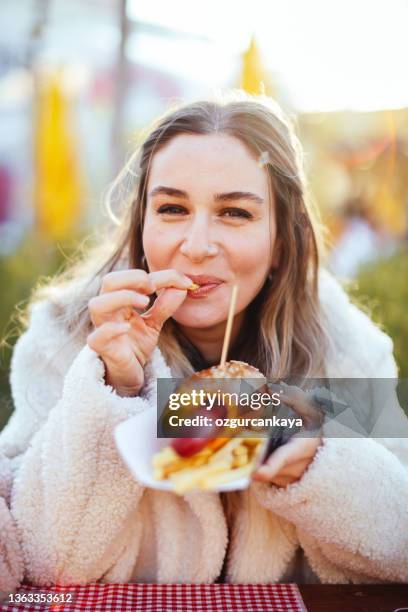 young pretty girl eating big hotdog in fastfood restaurant - hot big women stock pictures, royalty-free photos & images