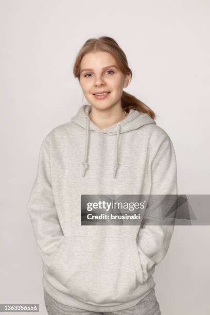 studio portrait of attractive 18 year old blonde woman on white background - women standing against grey background stock pictures, royalty-free photos & images