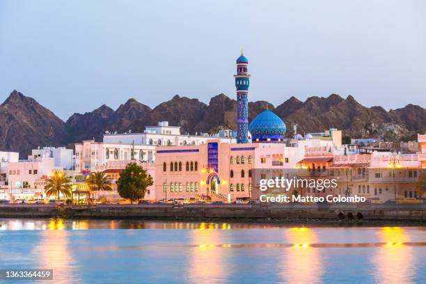 oman, muscat. mutrah harbour and old town at dusk - muscat stock-fotos und bilder