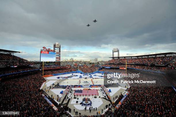 The Philadelphia Flyers and the New York Rangers line up for the National Anthem as US Air Force fighter jets fly over during the 2012 Bridgestone...