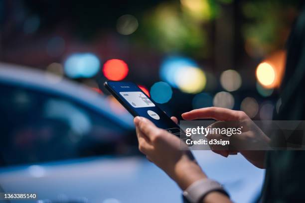 close up of young asian woman using mobile app device on smartphone to unlock the door of her intelligence car in city street, with multi-coloured city street lights in background. wireless and modern technology concept - auto tür offen stock-fotos und bilder