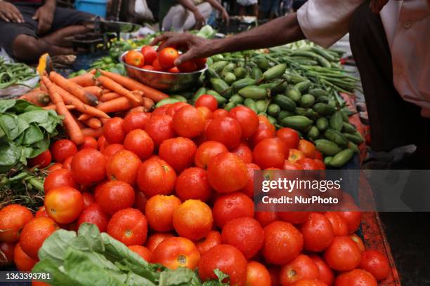 Indian Seller displaying Tomato and waiting for customer,The vegetable daily market in Kolkata,India on June 30,2023.Vegetable prices across the...