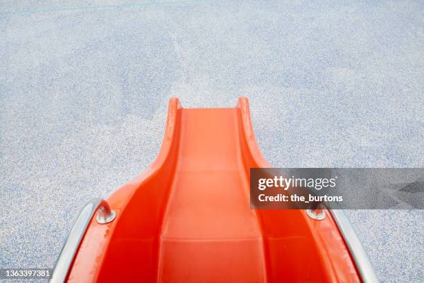 high angle view of red slide and speckled flooring - slide ストックフォトと画像